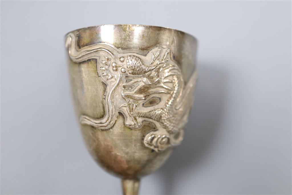 A pair of Chinese white metal pepperettes, 7cm, a similar salt, small goblet and a coin.